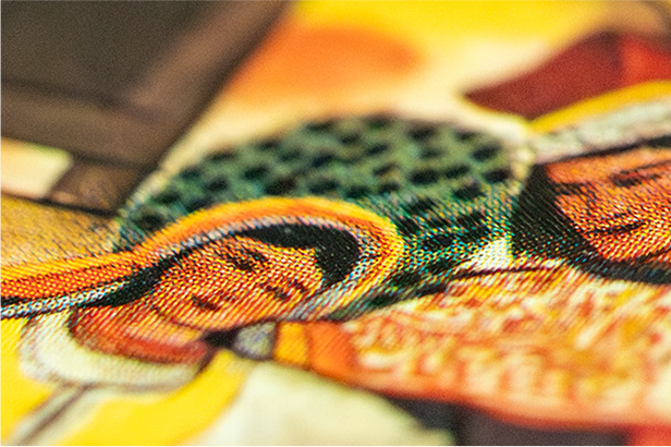 Zbliżenie na kolorową, teksturowaną ilustrację przedstawiającą dwie stylizowane postacie z ciemnymi włosami i aureolami. Lewa postać jest ubrana na żółto i biało, prawdopodobnie przedstawiając scenę religijną lub kulturową. Obraz zawiera kropki i linie typowe dla drukowanych dzieł sztuki.