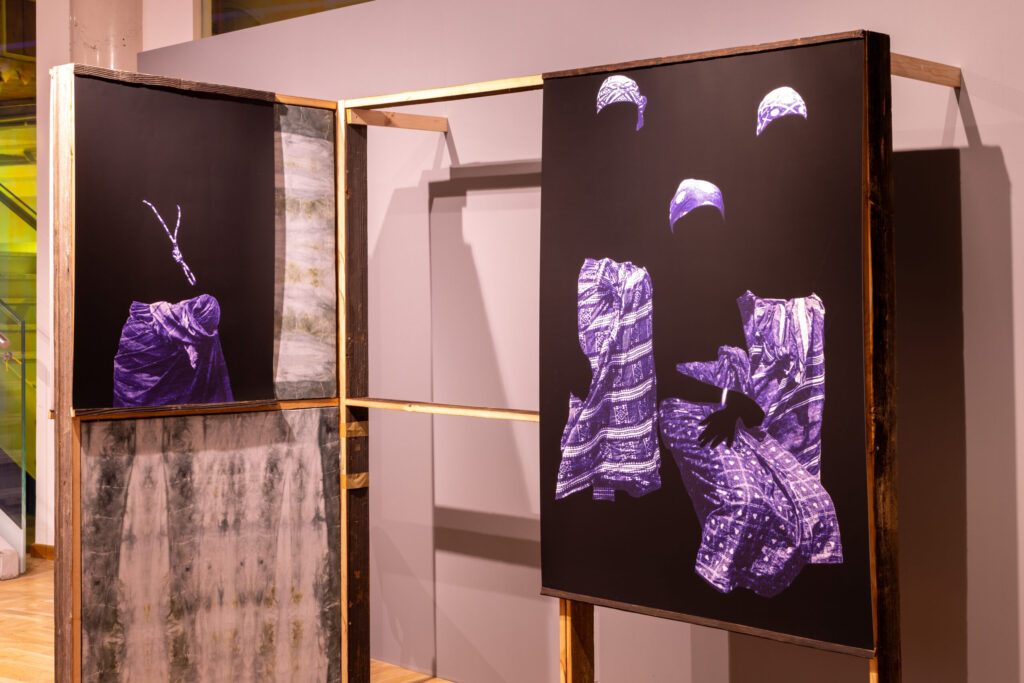 Instalacja artystyczna składa się z dwóch paneli oprawionych w drewno. Prawy panel przedstawia fragmentaryczne obrazy tradycyjnych fioletowych wzorzystych ubrań i nakryć głowy unoszących się na czarnym tle. Lewy panel przedstawia pojedynczą, podobnie ubraną postać i abstrakcyjne elementy.